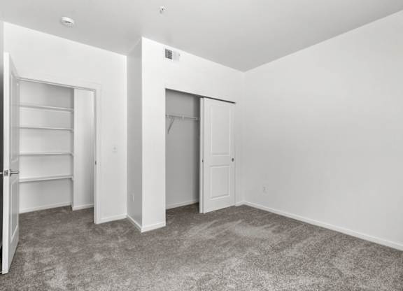 A room with a carpeted floor and white walls.
