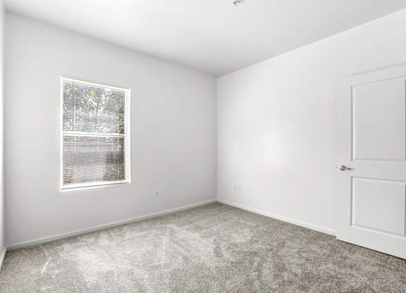 A white room with a door and a window.