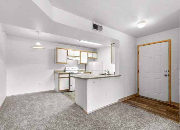 A small kitchen with white appliances and a white countertop.