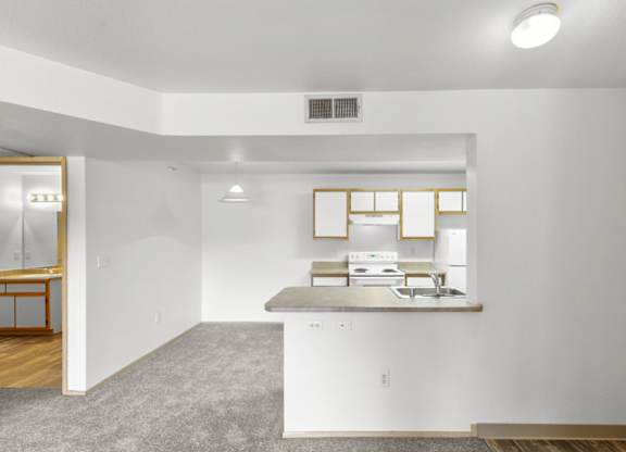 A kitchen with white cabinets and a window above the counter.