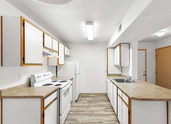 A kitchen with white appliances and wooden cabinets.