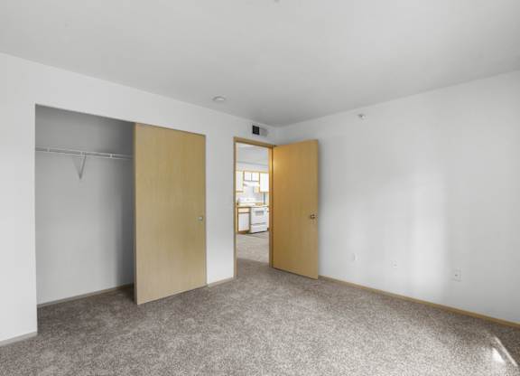 A room with a carpeted floor and two closed doors.