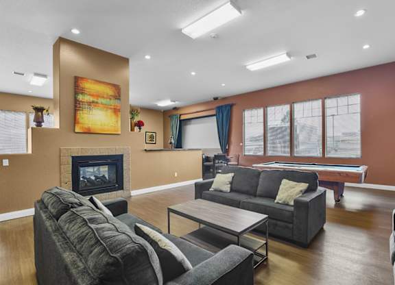 A living room with a grey couch and a fireplace.