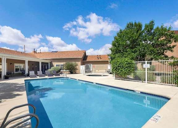 A swimming pool in a sunny outdoor setting.