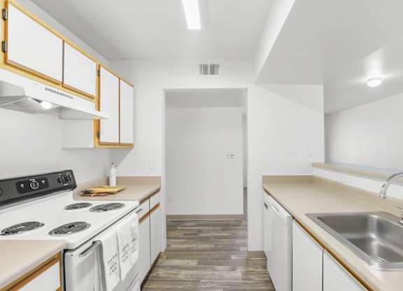 A kitchen with white cabinets and a black stove top.