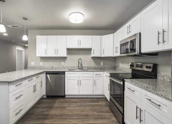 a large kitchen with white cabinets and stainless steel appliances
