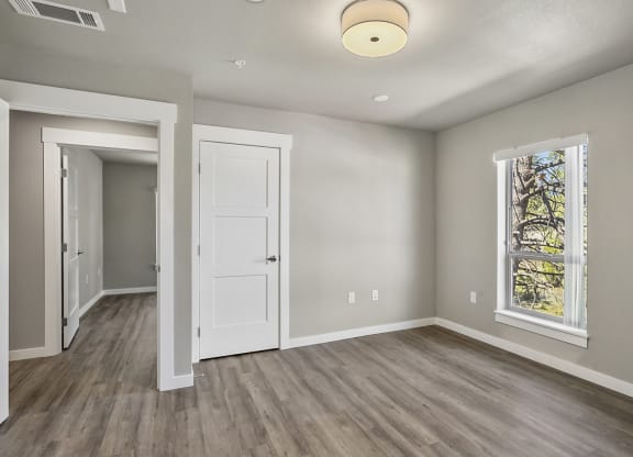 an empty room with hardwood floors and a large window
