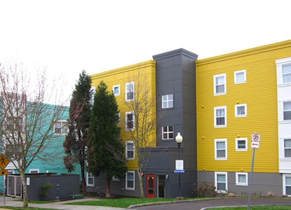 a yellow and gray building on the side of a street