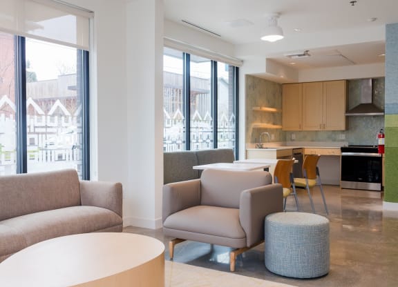 a living room with couches and chairs and a kitchen