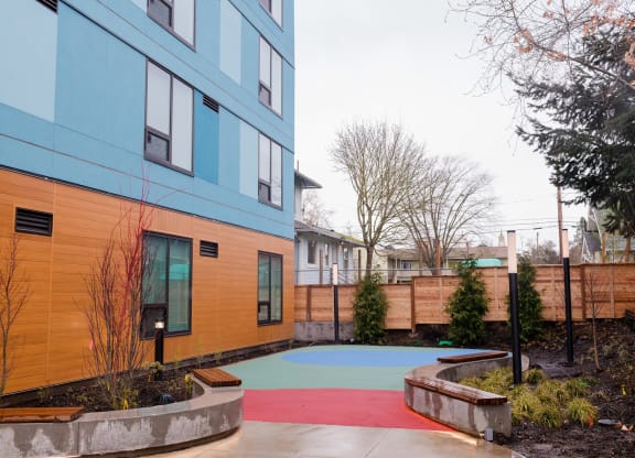 a courtyard with a blue building and a red and blue sidewalk
