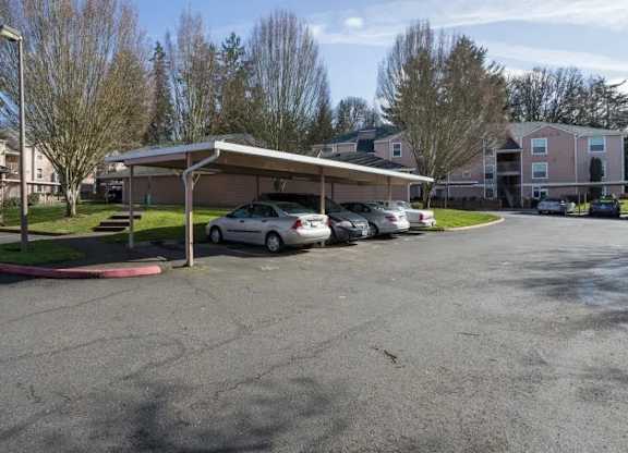 A parking lot with cars and a building in the background.