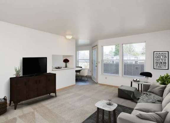 A living room with a grey couch, a black television, and a rug.