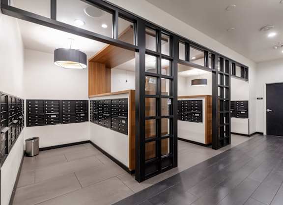 A modern office lobby with black and white decor and a trash can.