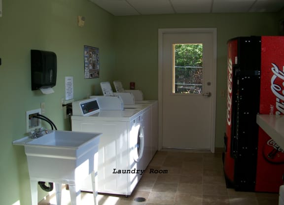 a laundry room with a coke machine and a sink