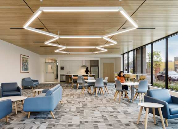 A modern cafeteria with blue chairs and tables.
