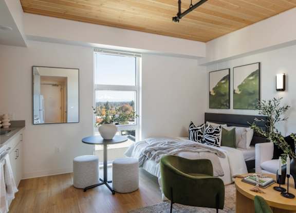 A modern bedroom with a large bed and a green armchair.