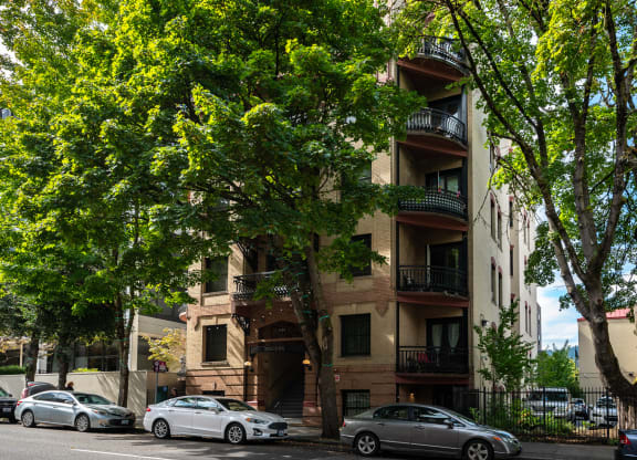 an apartment building with cars parked on the street