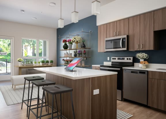 a kitchen with a large island with three bar stools