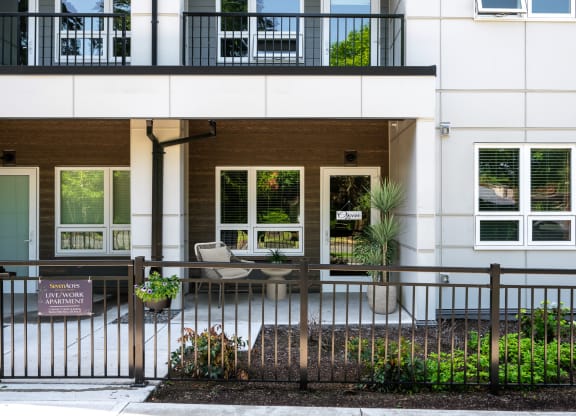 the front of a building with a fence and a patio
