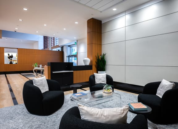 a living room with black chairs and a glass coffee table
