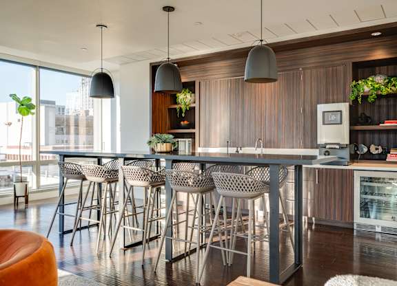 A modern kitchen with a bar area and chairs.