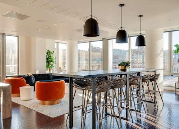 A modern dining room with a long table and chairs.