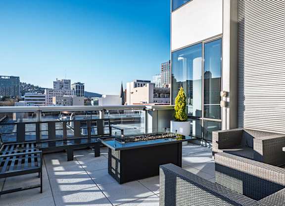 A patio with black furniture and a view of the city.