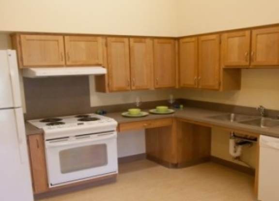 A kitchen with wooden cabinets and a white refrigerator.