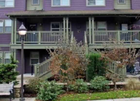 A purple building with a porch and a bench in front.