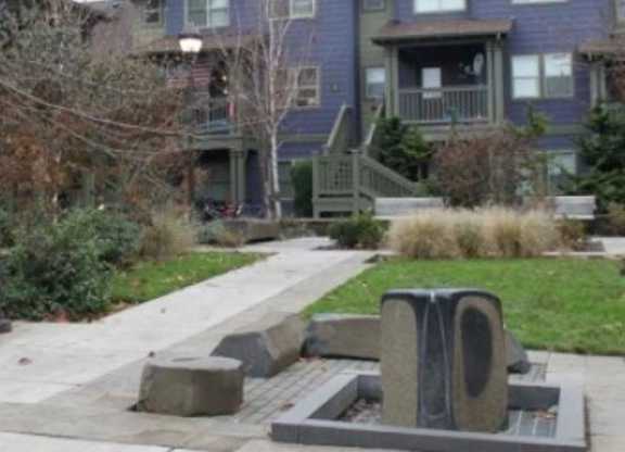 A blue house with a grey front yard.
