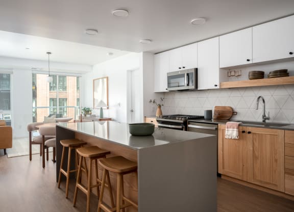 a kitchen with a large island and wooden chairs in a living room at Slabtown Square Apartments, Oregon, 97209