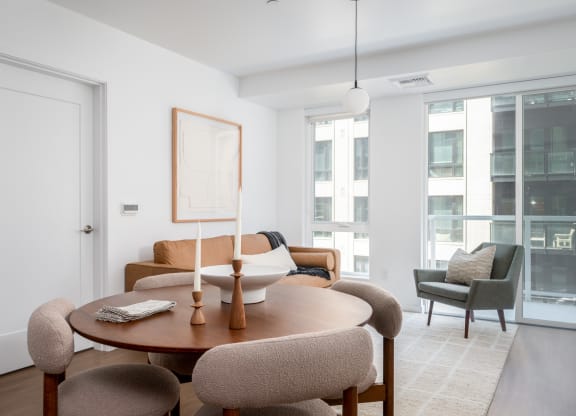 a living room with a table and chairs and a large window at Slabtown Square Apartments, Portland , Oregon
