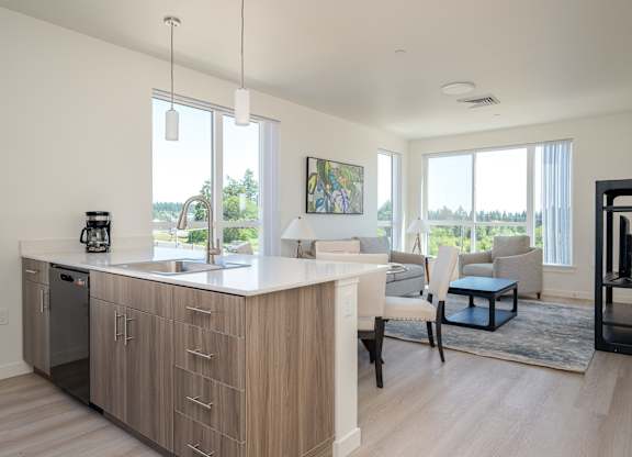 A modern kitchen with a large island and a view of the outdoors.