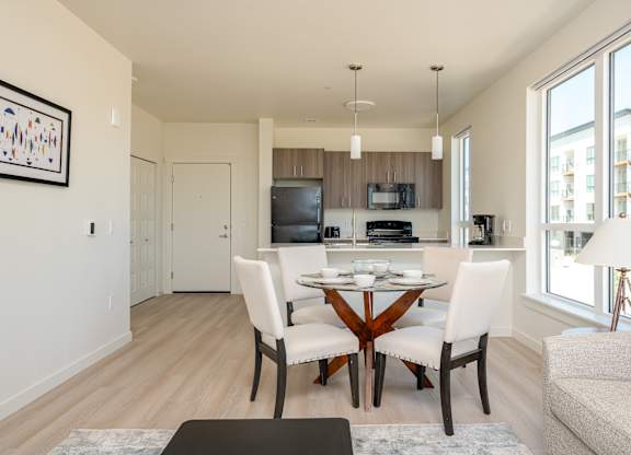 A modern kitchen with a dining table set for two.