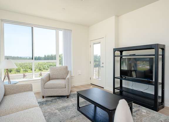 A living room with a black coffee table and a white chair.
