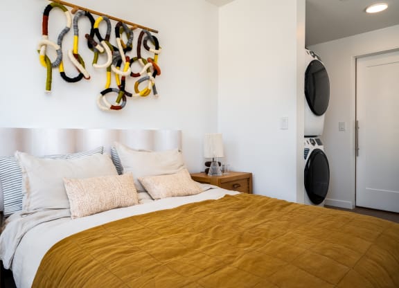 a bedroom with a bed and a wall with a rack of shoes on it at Slabtown Square Apartments, Portland , Oregon