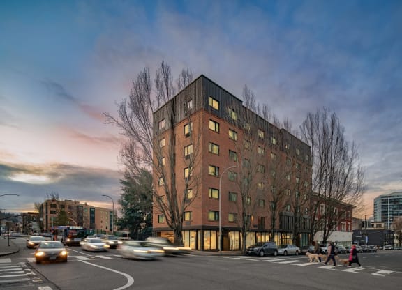 a tall brick building with a lot of windows and a street in front of it
