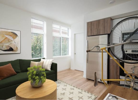 a living room with a green couch and a bicycle in the corner