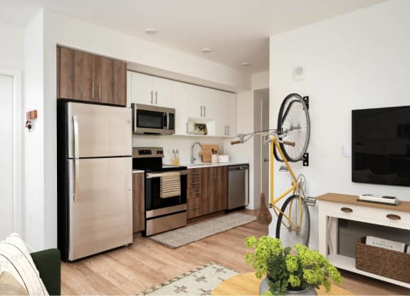 a kitchen with stainless steel appliances and a bike in a living room