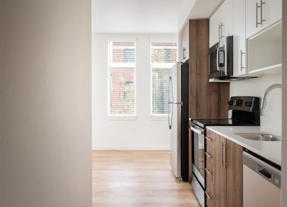 an empty kitchen with a sink and a refrigerator