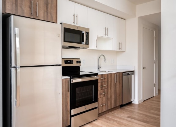 a kitchen with white cabinets and stainless steel appliances and a refrigerator