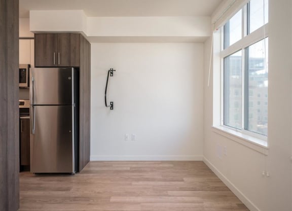 an empty room with a refrigerator and a window