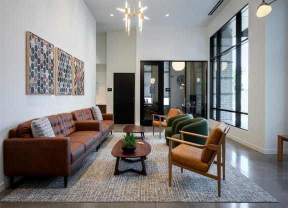 a living room with a couch and chairs and a rug