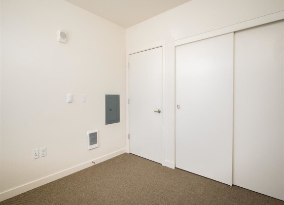 a bedroom with white walls and white doors and carpet