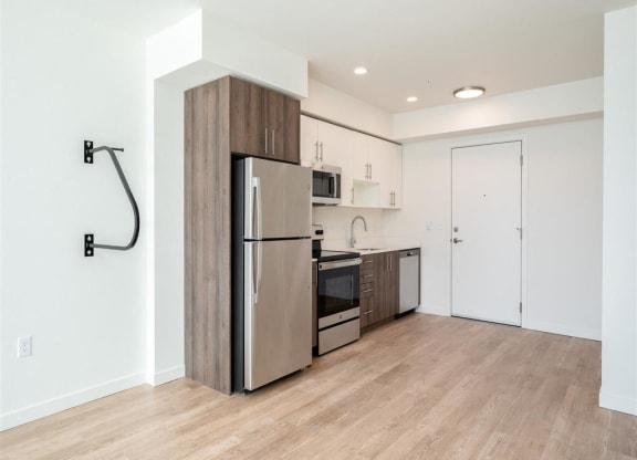 a kitchen with stainless steel appliances and a wood floor