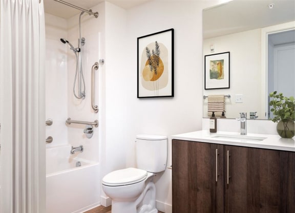 a bathroom with a toilet sink and shower and a mirror