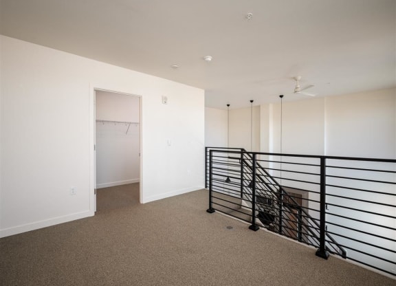 a room with white walls and a railing and a closet