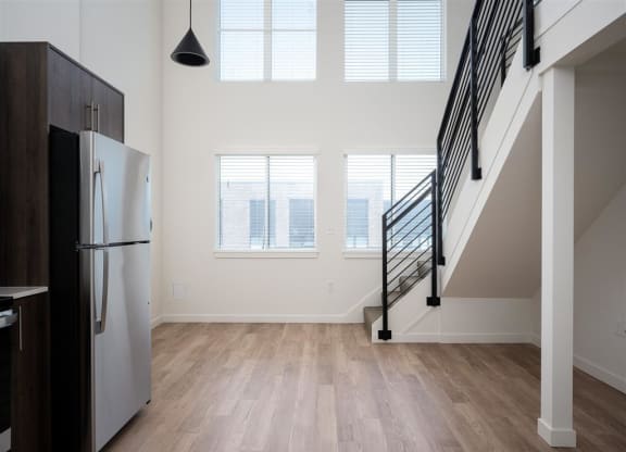 a kitchen with a refrigerator and a staircase in a house