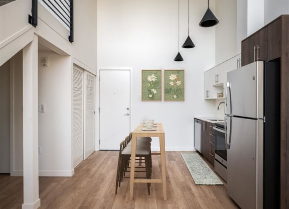 a kitchen with a wooden table and a refrigerator
