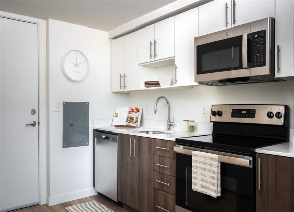 a kitchen with white cabinets and black appliances and a microwave